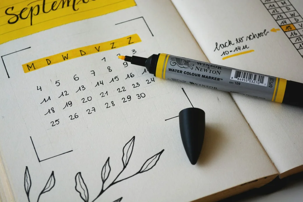Agenda papier avec calendrier mensuel rempli à la main et surligneur